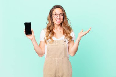 Güzel bir kadın mutlu, şaşırmış bir şekilde çözümü ya da fikri fark ediyor ve elinde bir akıllı telefon tutuyor.