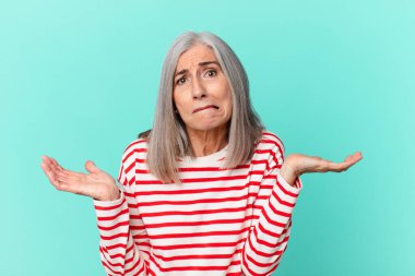 Orta yaşlı beyaz saçlı kadın şaşkın, şaşkın ve şüpheci.