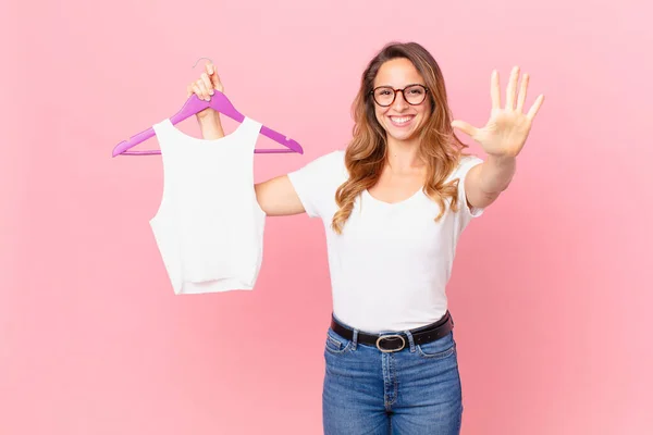 女性は笑顔で親しみやすく5番目の服を選び — ストック写真