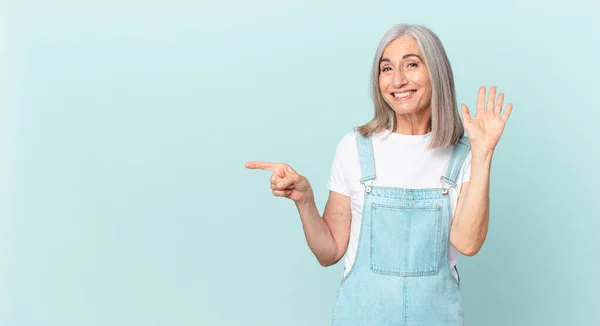 Medelålders Vitt Hår Kvinna Ler Glatt Viftande Hand Välkomnande Och — Stockfoto