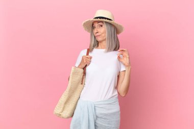 Orta yaşlı beyaz saçlı kadın kibirli, başarılı, pozitif ve gururlu görünüyor. yaz konsepti