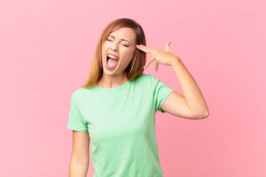 Güzel yetişkin bir kadın mutsuz ve stresli görünüyor, intihar jesti silah işareti yapıyor.