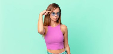 Güzel yetişkin bir kadın, kafası karışık ve şaşkın hissediyor, senin deli olduğunu gösteriyor.