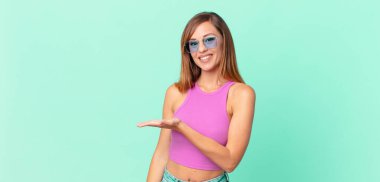 Güzel, yetişkin bir kadın neşeyle gülümsüyor, mutlu hissediyor ve bir konsept gösteriyor.