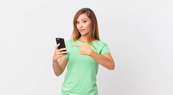 Pretty Woman Smiling Cheerfully Feeling Happy Pointing Side Using Smartphone — Stock Photo, Image