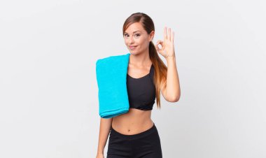 Güzel bir kadın kendini mutlu hissediyor, iyi bir jestle onaylıyor. fitness konsepti