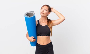 Güzel kadın şaşkın ve kafası karışık, kaşınan bir kafa hissediyor. yoga konsepti