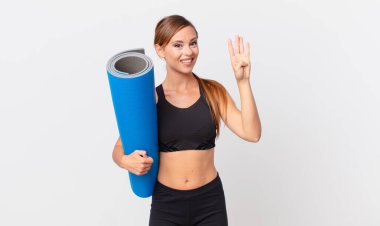 Güzel bayan gülümsüyor ve arkadaş canlısı görünüyor, dört numarayı gösteriyor. yoga konsepti