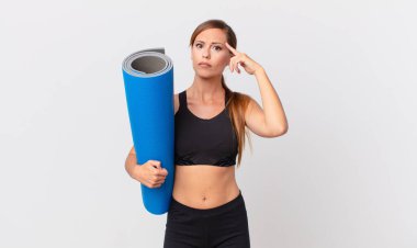 Güzel kadın şaşkın ve şaşkın hissediyor, senin deli olduğunu gösteriyor. yoga konsepti