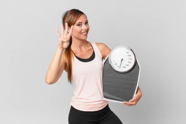 Güzel bayan gülümsüyor ve arkadaş canlısı görünüyor, dört numarayı gösteriyor. diyet kavramı