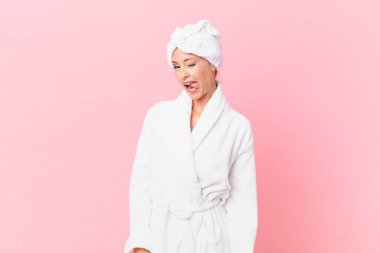 Neşeli ve asi tavırlı, şaka yapan ve dilini dışarı çıkaran güzel bir kadın. spa konsepti