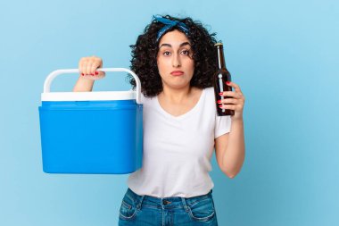 Portatif buzdolabı ve birası olan güzel bir Arap kadın.