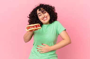 Güzel Arap kadın sosisli sandviç tutuyor. Fast food konsepti