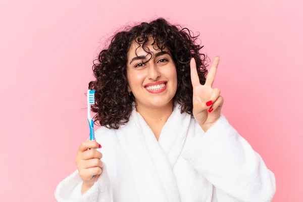 きれいなアラブ人女性がバスローブを着て歯ブラシを使って — ストック写真