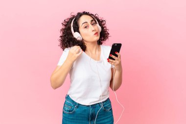 Güzel Arap kadın kibirli, başarılı, pozitif ve kulaklıklı ve akıllı telefonlu.