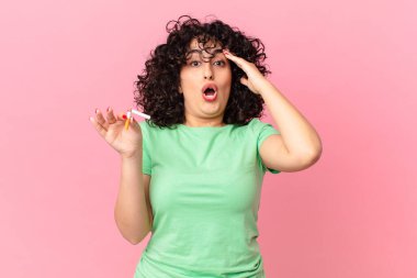 Güzel Arap kadın mutlu, şaşkın ve şaşırmış görünüyor. sigara içilmiyor