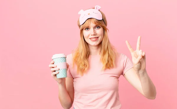 パジャマを着てコーヒーを飲んでるかなり赤い頭の女性 — ストック写真