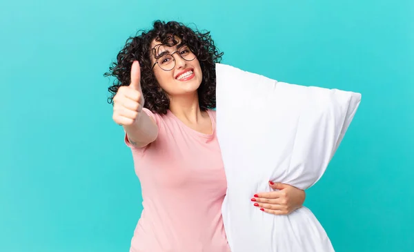 かなりアラブ人の女性は誇りを感じ 親指を上げて積極的に笑顔 パジャマを着て枕を持って — ストック写真