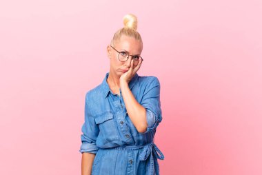 Güzel sarışın kadın bıkkın, yorgun ve uykulu hissediyor.