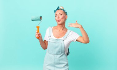 Güzel sarışın kadın stresli, endişeli, yorgun ve hayal kırıklığına uğramış ve duvar boyuyor.