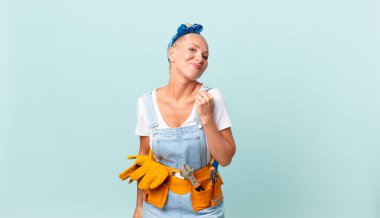 Güzel sarışın kadın kibirli, başarılı, pozitif ve gururlu görünüyor ve ev konseptini onarıyor.