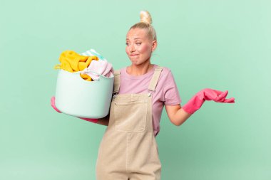 Güzel sarışın kadın şaşkın ve şaşkın hissediyor ve çamaşır yıkama konseptinden şüpheleniyor.