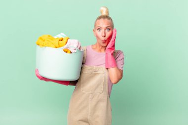 Güzel sarışın kadın şok olmuş ve korkmuş çamaşır yıkama konsepti.