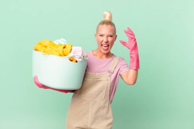 Güzel sarışın kadın ellerini havaya kaldırıp bağırıyor çamaşır yıkama konsepti.