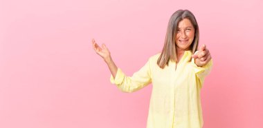 Güzel orta yaşlı bir kadın kamerayı işaret ederek seni seçiyor.