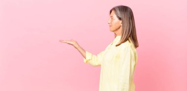 Profilde orta yaşlı güzel bir kadın hayal kuruyor, hayal kuruyor ya da hayal kuruyor.