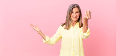 Güzel orta yaşlı bir kadın kapiş ya da para hareketi yapıyor, sana ödemeni söylüyor.