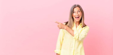 Güzel, orta yaşlı bir kadın heyecanlı ve şaşırmış görünüyor.