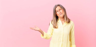 Güzel orta yaşlı kadın kafası karışmış ve şaşkın görünüyor.