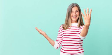 Güzel orta yaşlı bir kadın gülümsüyor ve arkadaş canlısı görünüyor.