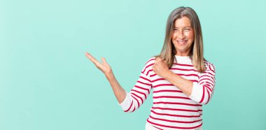 Güzel, orta yaşlı bir kadın kendini mutlu hissediyor ve zorluklarla yüzleşiyor veya kutlama yapıyor.