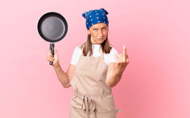 Oldukça orta yaşlı bir kadın kızgın, sinirli, isyankar ve agresif ve elinde bir tava tutuyor. Şef konsepti