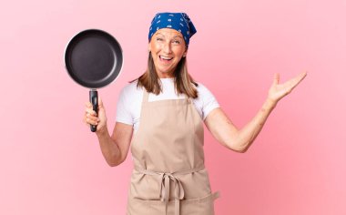 Oldukça orta yaşlı bir kadın mutlu hissediyor, bir çözüm ya da fikri fark edip elinde bir tava tutmasına şaşırıyor. Şef konsepti