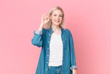 Sarışın, güzel bir kadın kendini mutlu hissediyor. Onayını veriyor.