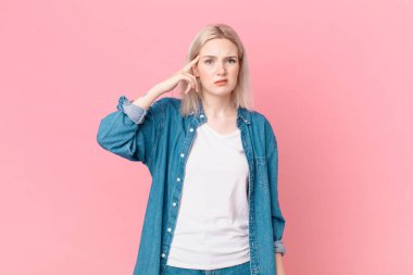 Sarışın, güzel bir kadın. Kafası karışık ve şaşkın. Deli olduğunu gösteriyor.