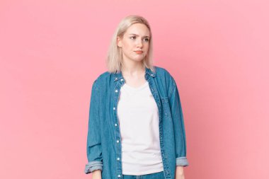 Sarışın, güzel bir kadın üzgün, üzgün ya da kızgın ve yana bakıyor.