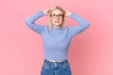 sarışın güzel bir kadın stresli, endişeli ya da korkmuş, elleri başının üstünde