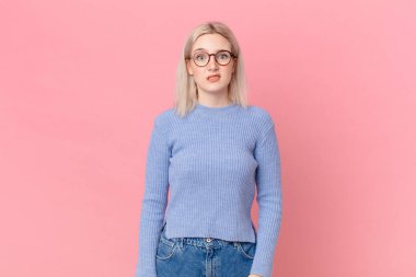 Şaşkın ve şaşkın görünen sarışın güzel kadın.