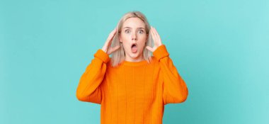 Sarışın, güzel bir kadın elleri havada çığlık atıyor.