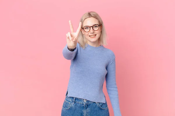 Rubia Bonita Mujer Sonriendo Mirando Feliz Haciendo Gestos Victoria Paz —  Fotos de Stock