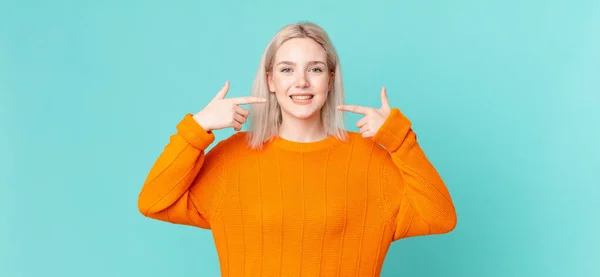 Blonde Hübsche Frau Lächelt Selbstbewusst Und Zeigt Auf Ihr Breites — Stockfoto