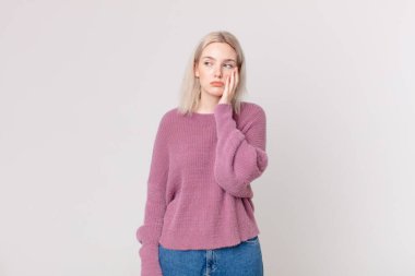 Sarışın, güzel bir kadın. Sıkılmış, hayal kırıklığına uğramış ve uykulu.