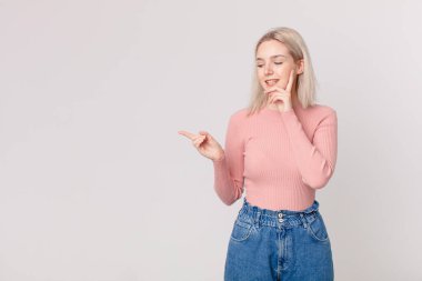 Sarışın, güzel bir kadın mutlu bir şekilde gülümsüyor ve hayal kuruyor.