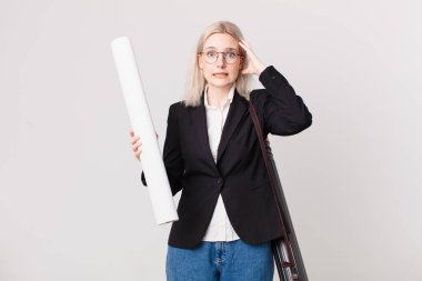 Sarışın, güzel bir kadın gergin, endişeli ya da korkmuş, elleri başının üstünde. mimar konsepti