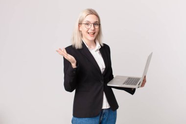 Sarışın, güzel bir kadın mutlu, şaşırmış bir şekilde çözümü ya da fikri fark ediyor ve elinde bir dizüstü bilgisayar tutuyor.