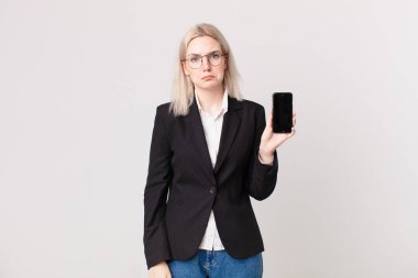 Sarışın, güzel bir kadın üzgün ve sızlanıyor. Mutsuz bir bakışla, ağlıyor ve elinde bir cep telefonu tutuyor.